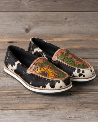 Pair of slip-on shoes with tribal designs on a white background