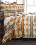 Bed with patterned quilt and pillows in a bedroom setting