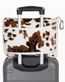 Wrangler Tri-Color Cowhide Travel Blanket shown in use on a suitcase in front of white backdrop.
