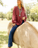 The Stillwater Tunic Top being styled and modeled by women riding horse in field.