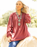 The Stillwater Tunic Top being styled and modeled by women riding horse in field.