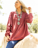 The Stillwater Tunic Top being styled and modeled by women riding horse in field.