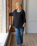 The Ellis Top in black being styled and modeled with jeans on women in studio setting.