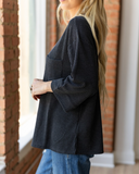 The Ellis Top in black being styled and modeled with jeans on women in studio setting.