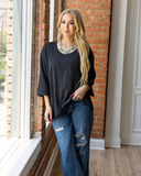 The Ellis Top in black being styled and modeled with jeans on women in studio setting.
