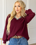 The Hadley Top in wine being styled with jeans and worn by a women in studio setting.