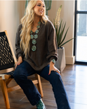The Hadley Top in mocha being styled and worn by a women in studio setting.