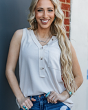 The Lanie Tank in Oatmeal being styled and modeled on women in front of wall.