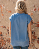The Sloan Top in denim blue being styled and modeled on women in front of brick wall.