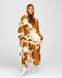 Person wearing a brown and white cow print blanket on a white background