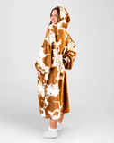 Person wearing a brown and white patterned blanket on a plain background