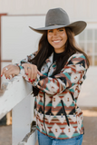 A model wearing the Southern Roots Soft Shell Jacket while leaning on a wooden fence.