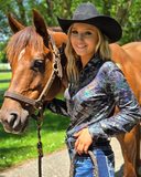 Woman in cowboy hat with a horse on a path with greenery