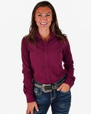 Woman wearing a maroon shirt and jeans on a white background