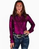 Woman wearing a shiny magenta shirt and blue jeans with a belt on a white background