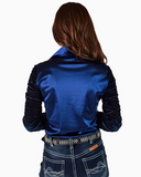 Person wearing a blue satin shirt and jeans on a white background