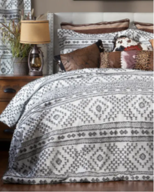 Bed with patterned bedding and decorative pillows in a bedroom setting.