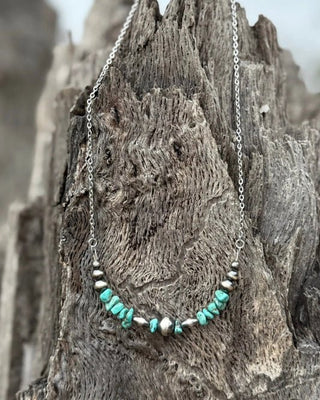 Necklace with turquoise stones on a textured wooden surface