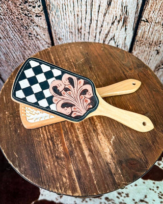 Checkered tooled hairbrush on a wooded stool