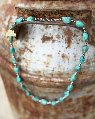 Turquoise beaded bracelet on a rustic wooden surface