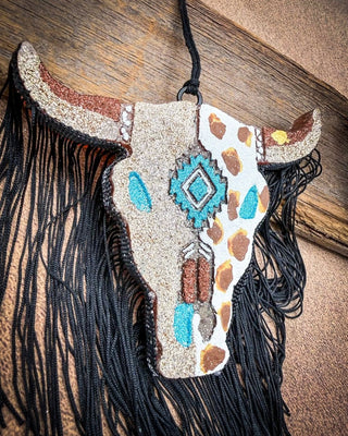Brown, turquoise and gold car freshie laying on wood