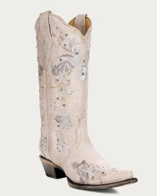 A single western cowboy boot in a light cream or off-white leather, decorated with silver and gray floral embroidery and sequined details, set against a solid light gray background.
