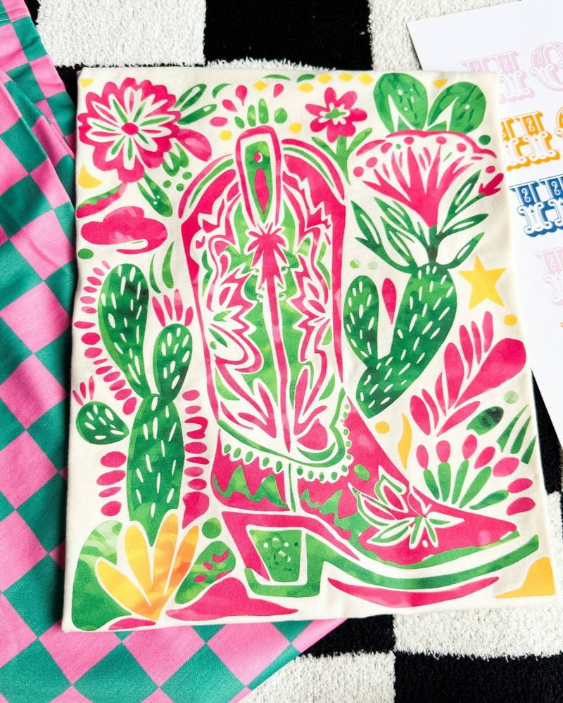 Colorful fabric with cowboy boot and cactus design on a checkered background