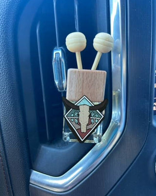 Car air freshener with a design on a blue car vent