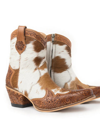 Cowboy boots with brown and white cowhide leather on a white background