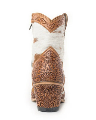 Close-up of a white cowhide boot with brown leather detailing on a white background
