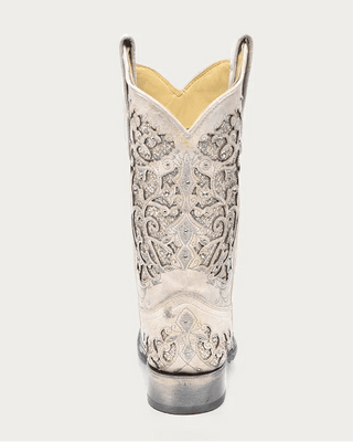 A single western cowboy boot shown from the back on a light gray background. The boot is off-white/cream with intricate silver embroidery and a yellow interior lining.
