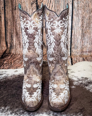 front of boots on cowhide, wood backdrop