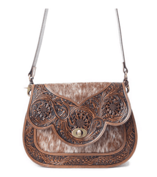 Western leather shoulder bag with cowhide accents displayed on a white background