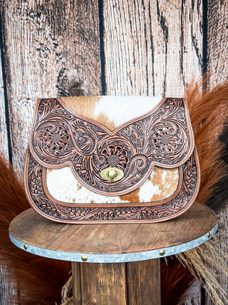 Western cowhide tooled leather purse with intricate floral design and twist lock