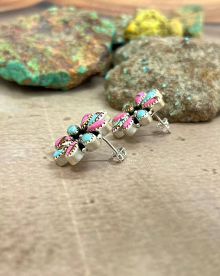 Pair of silver earrings with colorful beads on a wooden surface.