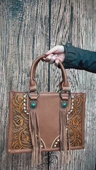 Classic western, elevated 🤎 The Canyon Nights Satchel is giving timeless leather, intricate tooling, and just the right amount of fringe.

✨ Spacious interior for everyday use
✨ Intricate floral tooling with silver concho details
✨ Built-in concealed carry pocket
✨ The kind of bag that gets compliments everywhere you go

This one’s made for the gals who want tradition with a little extra flair.