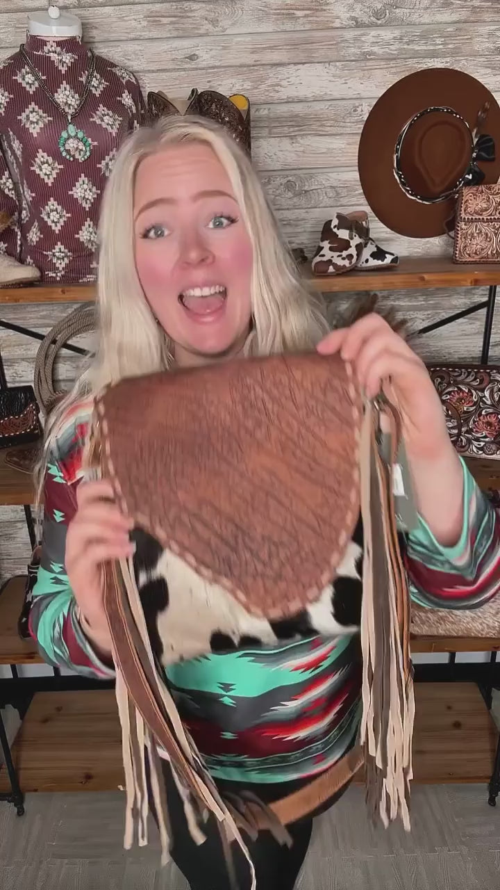 🤎 Fringe, cowhide, AND function? Say less. 🤎

The Chippy Fringed Concealed Carry Bag by Myra Bag is western perfection with a purpose. Between the bold fringe, rich leather flap, and genuine cowhide body, this bag was made to stand out. But the real win? It’s designed with a concealed carry pocket for practical, everyday use.

✔ Genuine cowhide + leather = one-of-a-kind
✔ Fringe for that extra western flair
✔ Concealed carry pocket for function + peace of mind

It’s not just a bag, it’s a statement. 👏