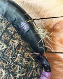 Black and purple netted bag with visible branding on a wooden surface