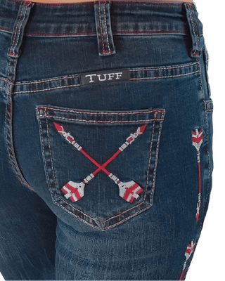 Close-up of the back of dark blue denim jeans worn by a model, featuring a black 'TUFF' brand patch on the back pocket and red-and-white embroidered crossed arrows on the pocket.