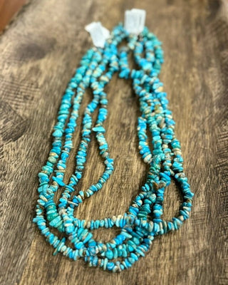 Turquoise beaded necklace on a wooden surface