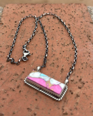 Necklace with a colorful pendant on a textured surface