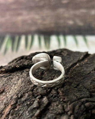 Silver ring on a textured wooden surface