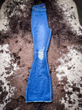 The Shannon Flare Jeans folded in half, showing the full length of the leg displayed on cowhide.