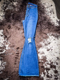 The Shannon Flare Jeans folded in half, showing the full length of the leg displayed on cowhide.