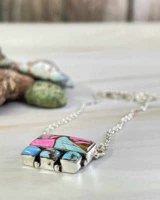 Necklace with a colorful pendant on a neutral background