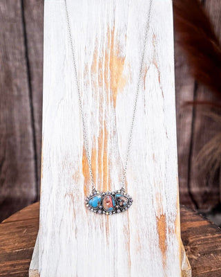 Rustic western three-stone necklace with turquoise and jasper on distressed white wood display