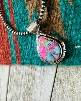 Necklace with a colorful pendant on a textured fabric background
