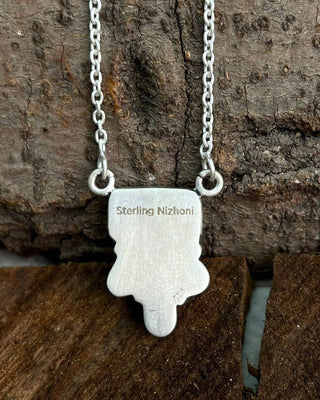 Silver pendant necklace on a wooden surface
