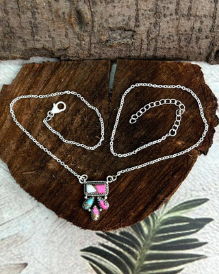 Necklace with a colorful pendant on a wooden surface