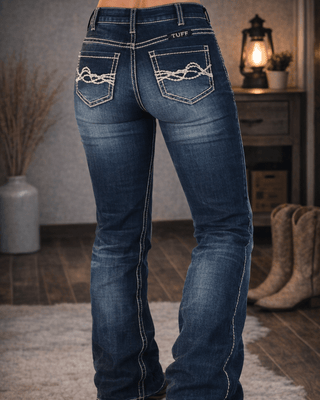 Blue jeans with white stitching worn by a person indoors.